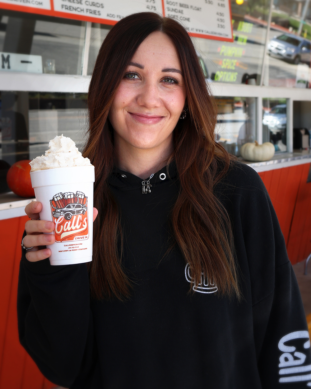Call's team member holding a Pumpkin Spice shake topped with whipped cream